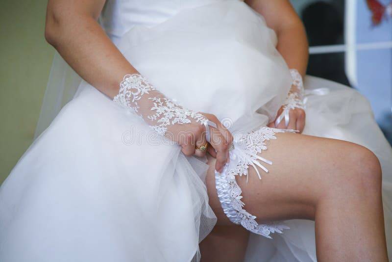 Почему невесту называют невестой. Подвязка жениха. Невеста надевает подвязку. Подвязка для невесты. Подвязка невесты в руке.